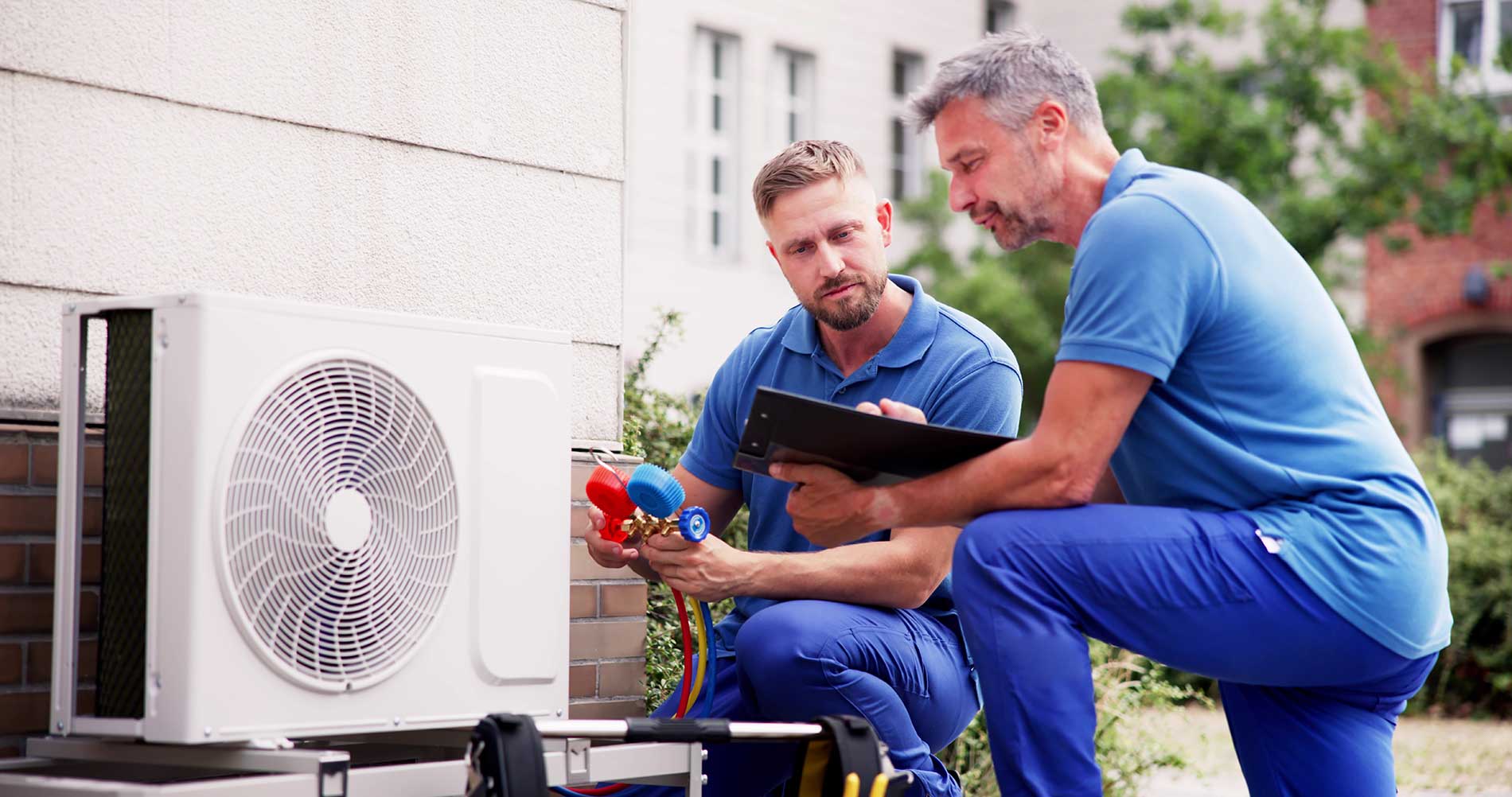 two-technicians-looking-at-heating-pump-for-checkups
